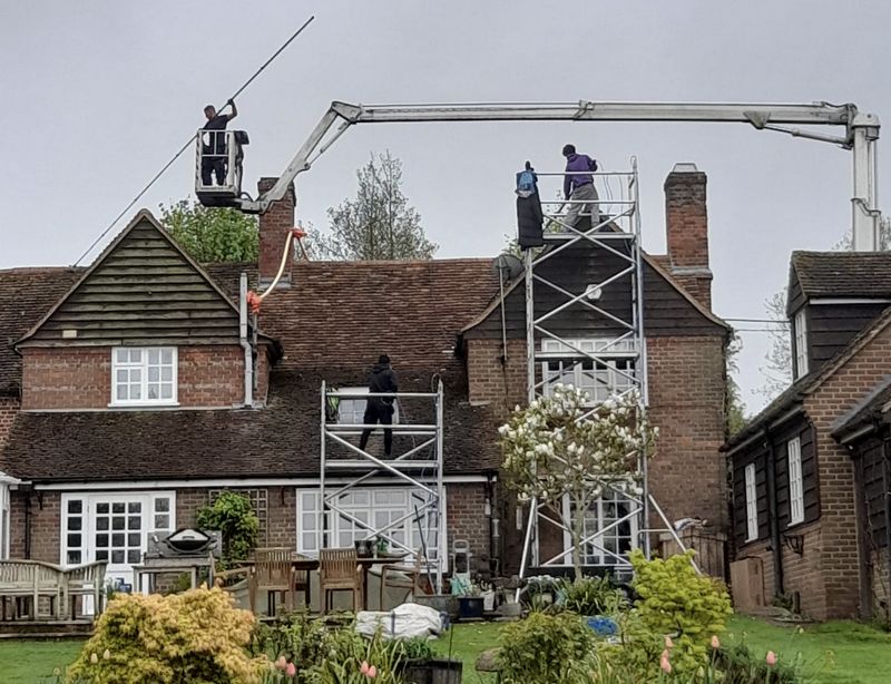 The Moss Cleaners using cherry picker and scaffolding to clean roof safely and professionally in Ashford, Surrey